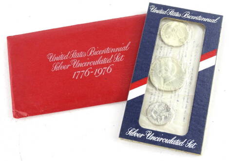 A United States bicentennial silver uncirculated set, commemorating 1776-1976, comprising an American silver dollar, half dollar and quarter dollar, in original packaging.