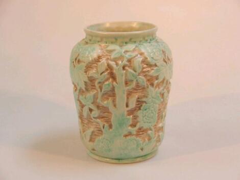 A Radford pottery vase modelled in relief with trees and vegetation