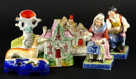 A collection of Staffordshire pottery, to include a pair of figures of a cobbler and lady, each with blue and white printed base, two cottages, spill vase and a greyhound shaped inkwell.