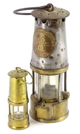 A brass and steel protector miners oil lamp, and a smaller example. (2)