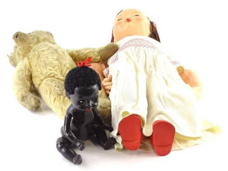 An early plastic child's doll with original clothing, and a Teddy bear. (2)