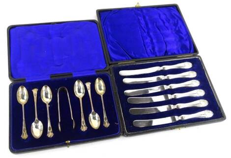 A set of six George VI silver teaspoons, each with a scroll cast handle and matching sugar tongues in a fitted case and a set of six silver and stainless silver dessert knives (cased).