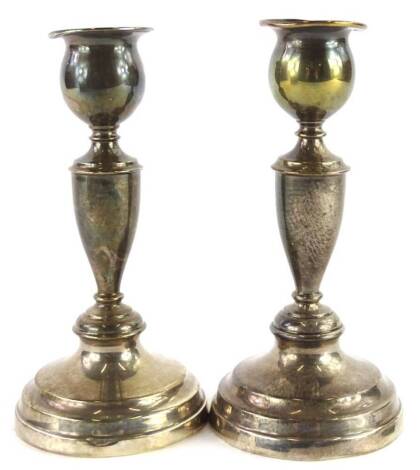 A pair of George V silver candlesticks, each with turned columned domed foot and turned mahogany bases, loaded, London 1923, 18cm H.