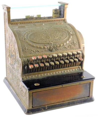 A late 19th/early 20thC National cash register, with gilt brass case, decorated with scrolls, leaves etc., number 791278,336 with imperial buttons etc., 40cm W overall.