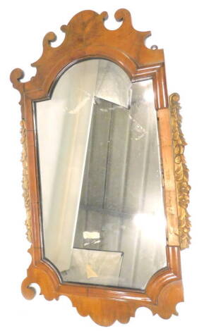 A walnut fret frame wall mirror, in mid 18thC style, with carved gilt sides, shaped crest etc., 95cm x 53cm. (AF)