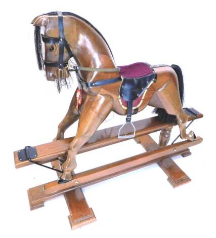 A carved beech rocking horse in Victorian style, on pine tressel type base, 140cm L.