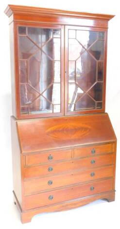 An Edwardian mahogany and rosewood cross banded bureau bookcase, the top with a moulded cornice with two astragal glazed doors, enclosing adjustable shelves, the base with four inlaid with an oval enclosing fitted interior and two short, three long drawer