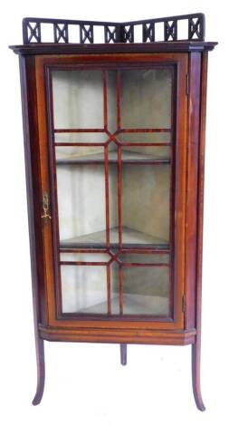 An Edwardian mahogany and boxwood strung corner display cabinet, with a pierced gallery above a single glazed door, on splayed legs, 48cm W.