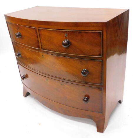 An early 19thC mahogany bow fronted chest of drawers, the caddy shaped top with a cross banded and boxwood strung border, above two short and two long drawers, each with turn wood handles on splayed feet, 98cm W.