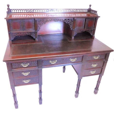 A late 19th/ early 20thC Edwards and Roberts writing table, in Chippendale style, the raised back with a pierced gallery, above a pair of small drawers and carved brackets, flanked by four pairs of slender turned columns, the base with a leather inset and