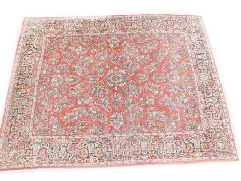 A Persian Meshed design carpet, with a design of flowers on a red ground with multiple borders, 366cm x 277cm.