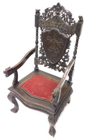 An oriental style throne type chair, the pierced back carved with birds, mythical beasts etc., surrounding a central cartouche, with a small padded seat, dragon carved arm rests, on cabriole legs.