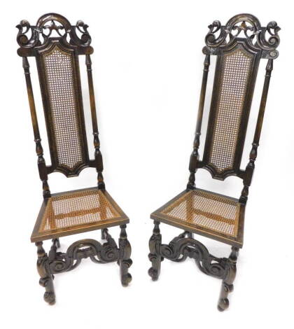 A pair of beech side chairs in early 18thC style, each with a caned back carved crest and cane seat, on shaped feet with stretcher.