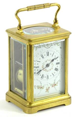 An early 20thC carriage clock, with fancy face decorated with flowers and a Roman numeric dial fronting a keywind movement, in a polished brass case with swing handle, 17cm H, (with key).