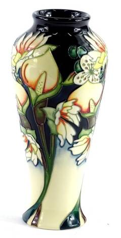 A Moorcroft pottery Royal Wedding pattern baluster vase, decorated with flowers on a navy blue ground, various marks to underside, the box titled A Royal Wedding, numbered 758, 21cm H.