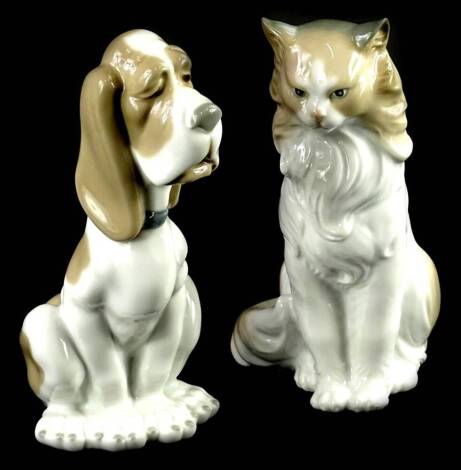 Two Nao ceramic figurines, one modelled in the form of a seated dog, the other a cat, 19cm H.