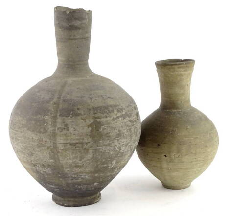 An ancient coiled pottery bottle shaped vase, 31cm H, and another similar, possibly Roman.