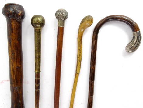 A collection of walking sticks, to include a walking cane with silver coloured metal mount, two with spherical handles etc.