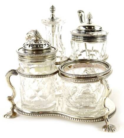 A Victorian silver cruet, comprising salts, pepper pot, on a loaded base, with leaf cast handle and feet, within beaded borders, London 1881.