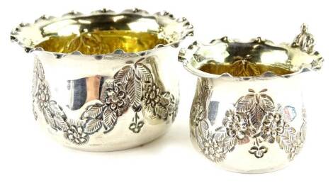 A George V silver small sugar bowl, embossed with swags of flowers, leaves and gilt interior, and a matching cup, 2oz.