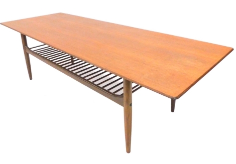 A retro style G-plan teak large coffee table, the rectangular top above a slatted magazine rack, on turned tapering legs, 160cm wide.