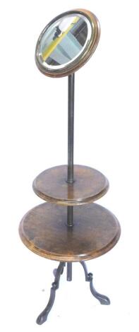 A Victorian walnut and brass shaving stand, with a circular bevelled mirror plate, with brass bezel on a cylindrical column, and tripod base, 136cm high.