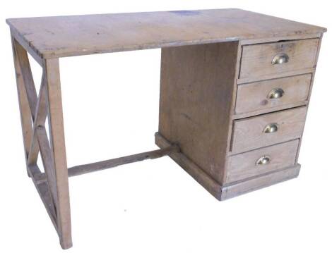 A pine and ply kneehole desk, with trestle end support and four drawers, each with brass handles on a plinth base, 124cm wide.