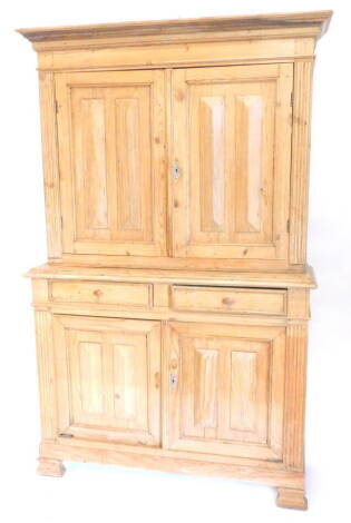 A 19thC stripped pine cupboard, the top with a moulded cornice with two panelled doors, the base with two drawers and two further doors, on block feet, 195cm H, 39cm D, 122cm W. Provenance: The property of Joan Stephenson, Kirkwood, North Church Walk, New