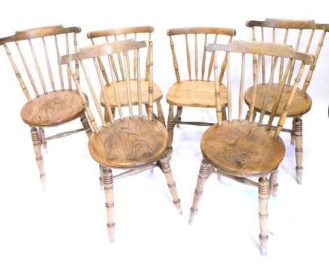 An associated set of six late 19th/early 20thC spindle back Windsor chairs, each with a solid seat on turned tapering legs.