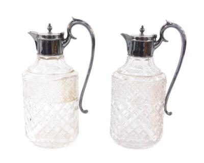 A pair of cut glass claret jugs with silver mounts, scroll handles and hinged lids, Garrard & Company Ltd, London 1961, 30cm H.