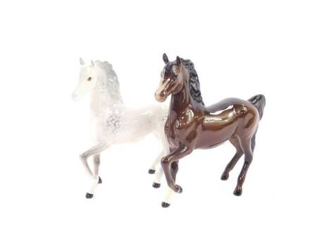 A Beswick Palomino prancing horse, together with a similar brown gloss prancing horse, printed marks (2).