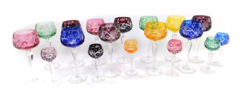 A set of twelve vari-coloured cut glass hock glasses, raised on hexagonal stems, together with six smaller glasses (18).