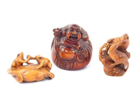 Two Japanese late 20thC carved wooden netsuke, signed, one with two frogs on a lily pad in an arm wrestle, 5cm long, the other of two birds kissing, 4.5cm H, together with a wooden carving of a seated Buddha, 5cm H. (3)