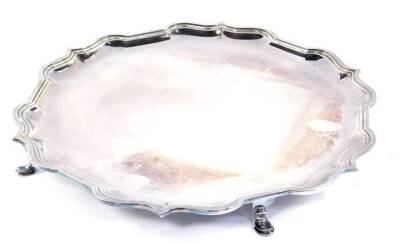 A silver piecrust salver, raised on four hoof feet, Sheffield 1971, 27.15oz, 31cm Dia.