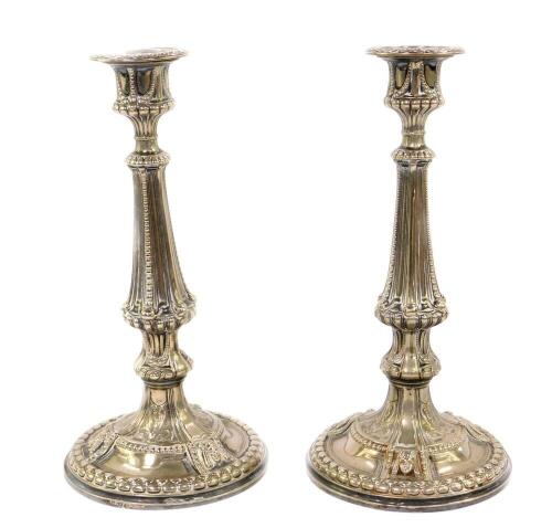 A pair of Victorian Elkington & Company silver plated candlesticks, embossed with beading, foliate scrolls and masks, raised on a conical foot, 27.5cm H.