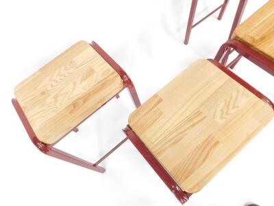 A set of four burgundy metal laboratory stools, with oak seats and metal cross bars, each 64cm H. - 3