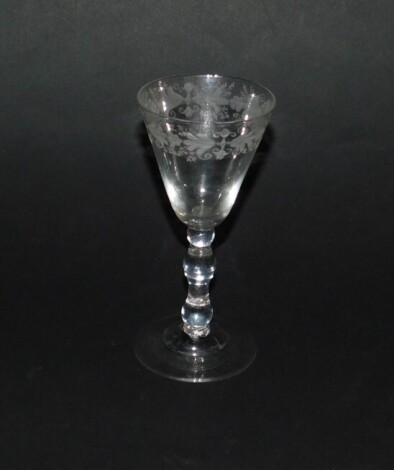 A continental 18thC wine glass, possibly French, the bowl engraved with flowers and scrolling leaves, raised on a triple knop stem and domed conical foot, 16cm H.