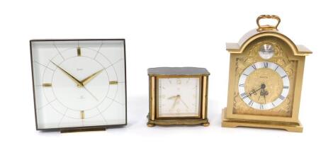 A Swiza Tempus Fugit brass cased mantel clock, 11cm W, a further Swiza mantel clock, with a square dial, brass cased, 12cm W and a Jaz Deluxe serpentine cased bedside clock, brass and black plastic cased, 9cm W. (3).