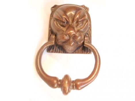 A bronze door knocker cast as a lion mask with ring striker