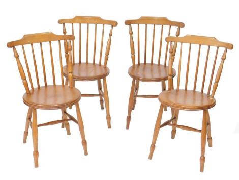 A set of four oak and elm spindle back kitchen chairs, with circular seats raised on turned legs united by an H frame stretcher.