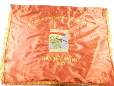 A Vietnam War era Vietcong silk victory flag, stitched with a soldier, "ANH DUNG KIENA WONG BINH GIA LUC LUONG VO TRANG GIAI PHONG MIEN NAM VIET NAM, CHIEN THANG BINH GIA", 1967, 67cm H, 93cm W.