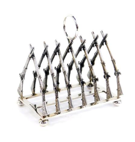 A silver six division toast rack, formed as fourteen crossed rifles, London 2000, 10.09oz.