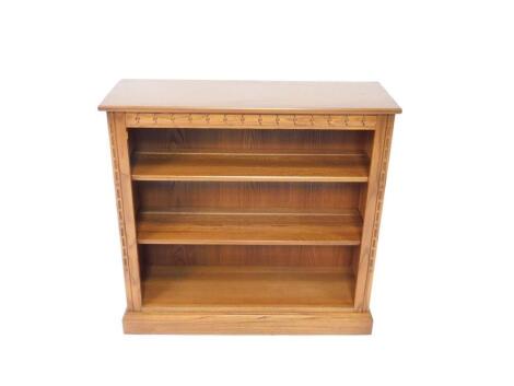 An Ercol oak open bookcase, with two shelves raised on a plinth base, 92.5cm H, 96cm W, 34cm D.