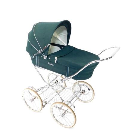 A Silver Cross pram, with a green basket and levered hood, white metal frame, 115cm H, 111cm W, 56cm D.