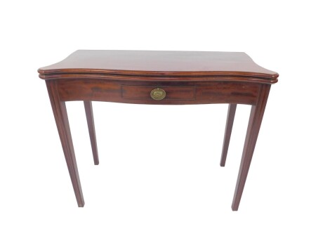 A George III mahogany tea table, with serpentine plum pudding folding top, having thumb nail border and with a small drawer with oval backplate handle to the plain frieze, raised upon triple fluted square tapered legs, 72cm H, 92cm Sq. Provenance: The St 