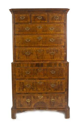 An early 18thC figured walnut chest on chest or tall boy, with moulded cornice, fluted canted corners, enclosing three short over three graduated drawers to the upper section, each having herringbone stringing and cross banding and three further graduated