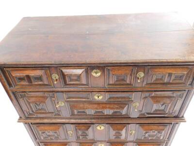 A late 17thC/early 18thC oak chest of drawers, in two parts, the top section with a planked top and moulded edge above two drawers with raised panels and brass tear drop handles, the base with two similar drawers above a moulded skirt and block feet, 105c - 2