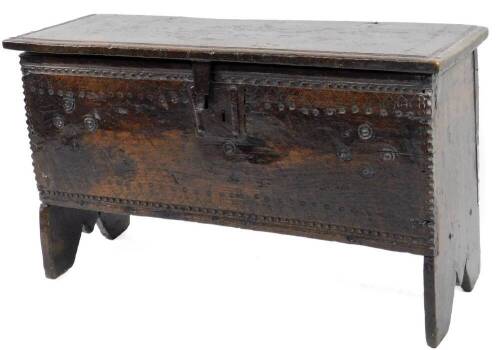 A 17thC small oak boarded chest, the top with shaped edge, the base with a shallow carved frieze and iron lock and also decorated with patera and roundels, on fishtail end supports, 47cm H, 80cm W, 29cm D.