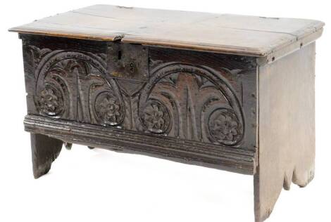 A 17thC oak small boarded chest, with a rectangular top with moulded edge above a frieze carved with arches, roundels, etc., on fishtail type end supports, 37cm H, 64cm W.