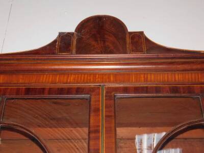 A George III mahogany secretaire bookcase, with a stepped arch pediment with satinwood stringing, flame frieze over two tall hour glass and diamond shaped astragal doors, the fall front secretaire drawer having satinwood and ebony stringing with flamed ca - 3